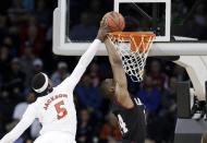 Cincinnati's Justin Jackson (5) tries to stop a shot by Harvard's Steve Moundou-Missi in the first half during a second-round game of the NCAA college basketball tournament in Spokane, Wash., Thursday, March 20, 2014. (AP Photo/Elaine Thompson)