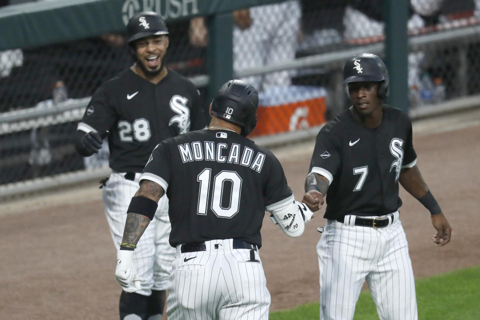 Chicago White Sox's Yoan Moncada (10) is greeted outside the dugout by Leury Garcia (28) and Tim Anderson, after Moncada's three-run home run off Minnesota Twins starting pitcher Jose Berrios during the second inning of a baseball game Friday, July 24, 2020, in Chicago. (AP Photo/Charles Rex Arbogast)