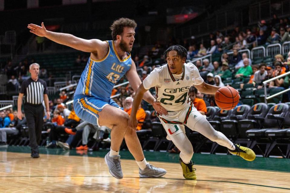 Miami Hurricanes guard Nigel Pack (24) drives on Long Island University center Gezim Bajrami (43) during the second half of an NCAA basketball game at the Watsco Center in Coral Gables, Florida, on Wednesday, December 6, 2023.