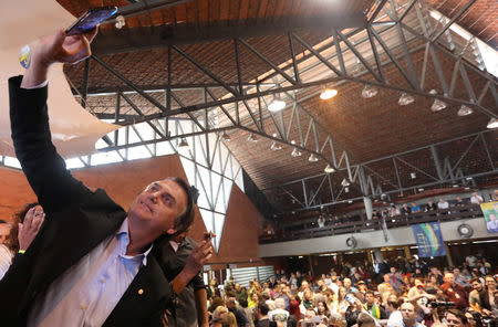 FILE PHOTO - Presidential candidate Jair Bolsonaro takes a selfie as he attends a rallyin Porto Alegre, Brazil August 30, 2018. Picture taken August 30, 2018. REUTERS/Diego Vara