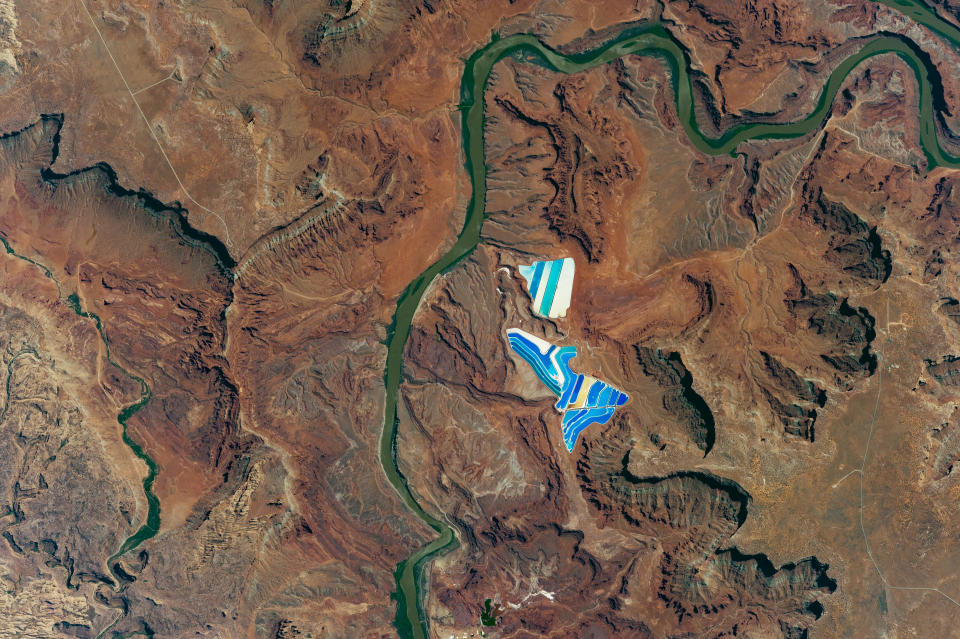 <p>A photo taken on Aug. 9, 2017 by an astronaut aboard the International Space Station of solar evaporation ponds outside the city of Moab, Utah, part of a operation to mine potassium chloride —  more commonly referred to as muriate of potash (MOP) — from ore buried underground. Each pond color indicates a different state of evaporation. The deep blue color is from a dye added to ponds of potash brine and water in order to speed up the rate of heat absorption. The seafoam green indicates shallower waters that are well into the evaporation process. The tan colored ponds are nearly dry; salt crystals (the final product) are left over in the pond and ready for collection. (Photo: NASA/Handout via Reuters) </p>