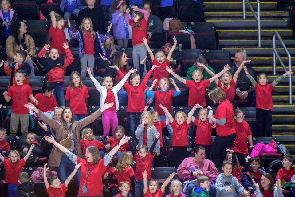 A group of young students in red dance to the Village People's "YMCA" during Peoria Rivermen Education Day festivities Thursday, Dec. 14, 2023 at Carver Arena. A record crowd topping 8,000 gathered to watch the Rivermen blank the Quad City Storm 2-0.