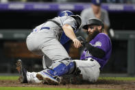 Los Angeles Dodgers catcher Will Smith, front, applies a late tag as Colorado Rockies' Charlie Blackmon scores on a double hit by C.J. Cron in the seventh inning of a baseball game Wednesday, Sept. 22, 2021, in Denver. (AP Photo/David Zalubowski)