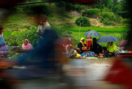 A vehicle passes new Rohingya refugees, who are waiting on the road side near the Balukhali makeshift refugee camp, in Cox’s Bazar, Bangladesh, August 30, 2017. REUTERS/Mohammad Ponir Hossain