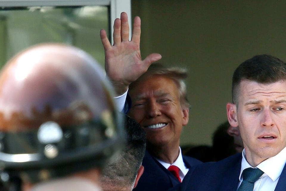 Former US President Donald Trump waves as he makes a visit to the Cuban restaurant Versailles after he appeared for his arraignment on 13 June, 2023 in Miami, Florida (Getty Images)