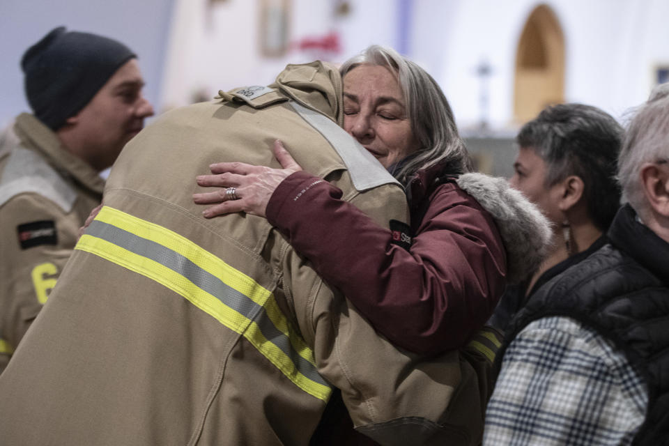 Community members embrace during a vigil for the six people killed in a plane crash, in Fort Smith, Northwest Territories, on Wednesday, Jan. 24, 2024. (Jason Franson/The Canadian Press via AP)