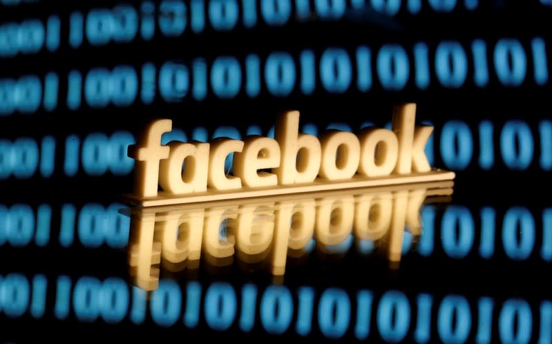 FILE PHOTO: Facebook logo is seen in front of displayed binary code in this illustration picture