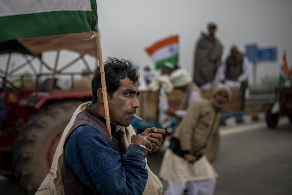 A farmer smokes a bidi, or hand-rolled cigarette, during a tractor rally to protest new farm laws in Ghaziabad, on the outskirts of New Delhi, India, on Jan. 7, 2021. (AP Photo/Altaf Qadri)