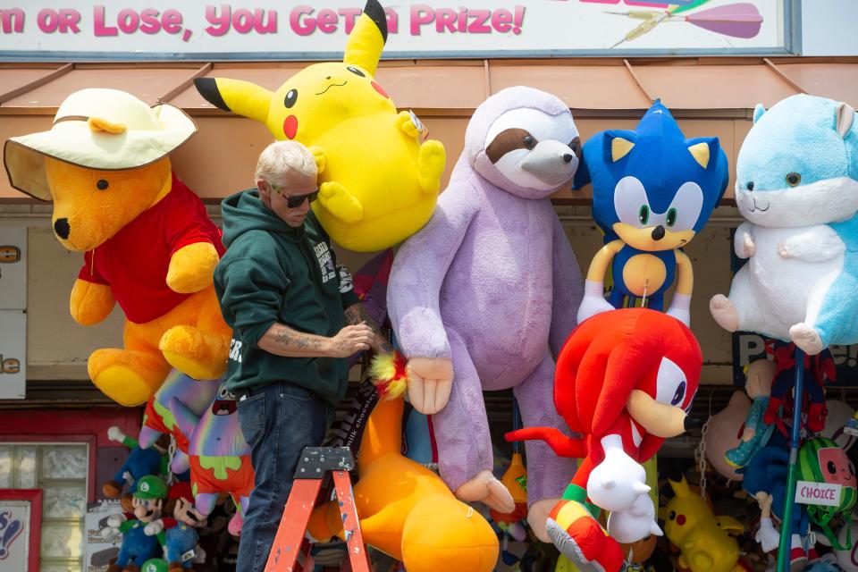 Whitey Stell of Uncle Vinnie’s Balloon Game hangs prizes. The summer tourism season kicks off this weekend, and Shore businesses are hoping to improve on last year, when Monmouth and Ocean County visitors generated $8.2 billion. Small business owners along the boardwalk prepare for the holiday weekend.  Seaside Heights, NJTuesday May 123, 2023