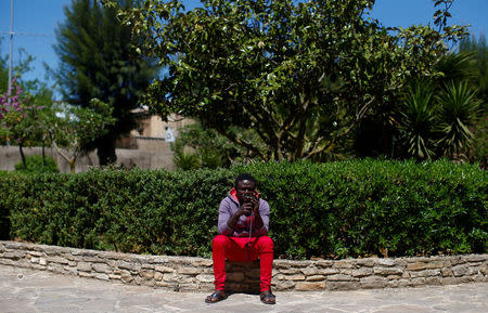 An adolescent migrant uses his mobile phone at an immigration centre in the Sicilian town of Caltagirone, Italy April 20, 2016. REUTERS/Tony Gentile