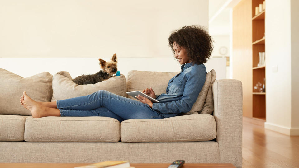 Shot of a young woman relaxing on the sofa with her digital tablet at home.