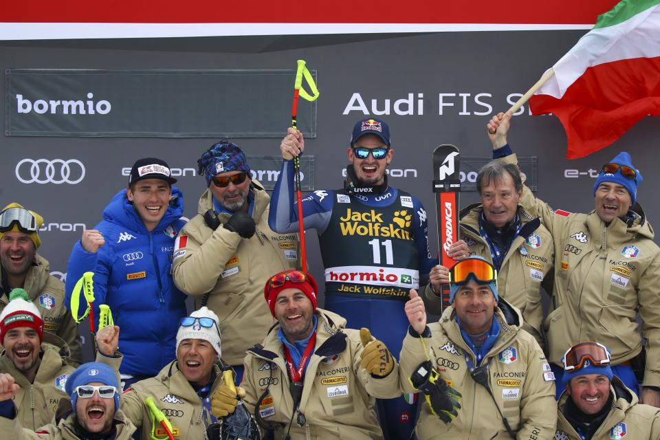 Italy's Dominik Paris, center, celebrates with the Italy team after winning an alpine ski, men's World Cup downhill, in Bormio, Italy, Friday, Dec. 27, 2019. (AP Photo/Alessandro Trovati)