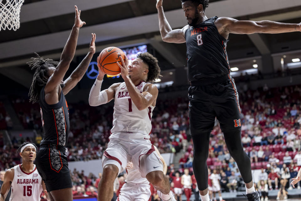 Alabama guard Mark Sears (1) shoots at the buzzer for two points with Mercer guard David Thomas, front left, and forward Amanze Ngumezi (8) guarding the play during the first half of an NCAA college basketball game, Friday, Nov. 17, 2023, in Tuscaloosa, Ala. (AP Photo/Vasha Hunt)