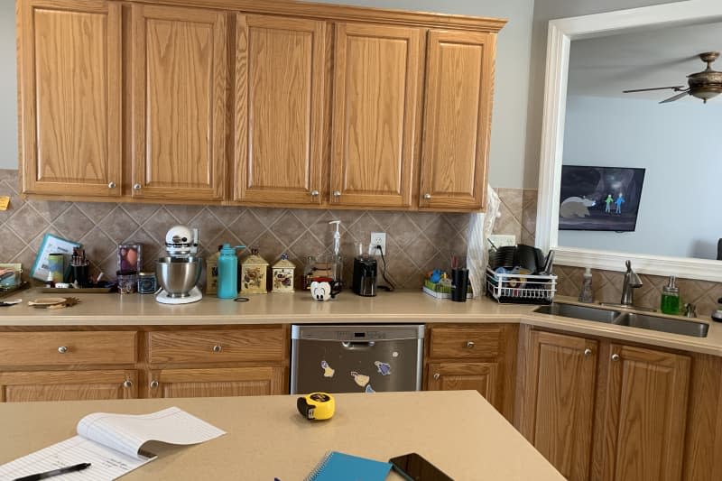 Unrenovated brown and gray kitchen with wooden cabinets