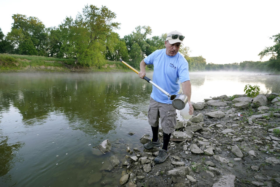 Des Moines Water Works employee Bill Blubaugh collects a water sample from the Raccoon River, Thursday, June 3, 2021, in Des Moines, Iowa. Each day the utility analyzes samples from the Raccoon River and others from the nearby Des Moines River as it works to deliver drinking water to more than 500,000 people in Iowa's capital city and its suburbs. (AP Photo/Charlie Neibergall)