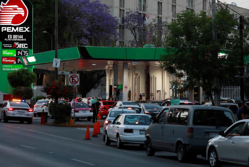 Cars line up to fill their tanks at a gas station offering the lowest price for a liter of gas in Mexico City