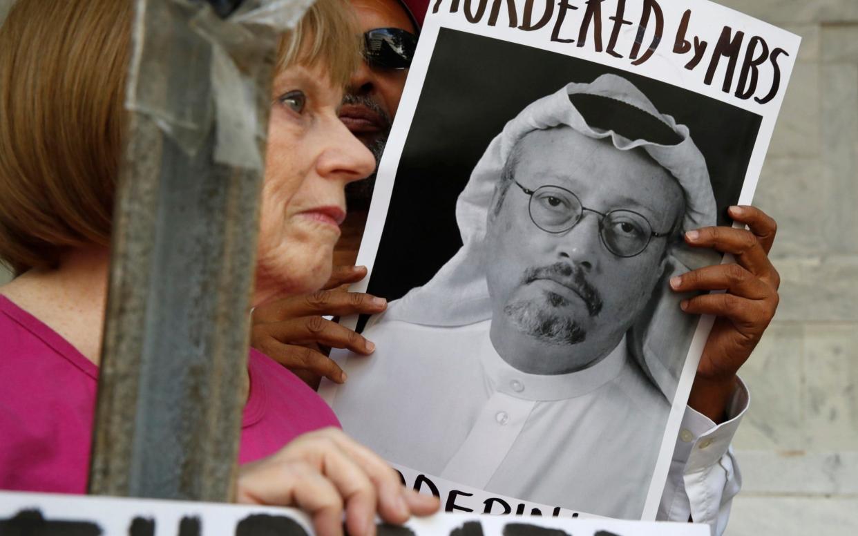 People hold signs during a protest at the Embassy of Saudi Arabia about the disappearance of Saudi journalist Jamal Khashoggi in Washington - AP