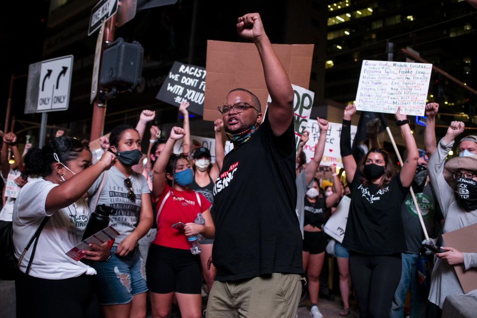 Jacob Raiford holds up his fist while marching on the 57th anniversary of the historic March on Washington on Aug. 28, 2020, in Phoenix.