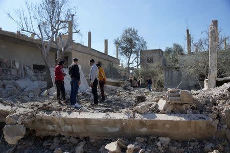 People inspect the damage after airstrikes by pro-Syrian government forces in the rebel held town of Dael, in Deraa Governorate, Syria February 12, 2016. REUTERS/Alaa Al-Faqir