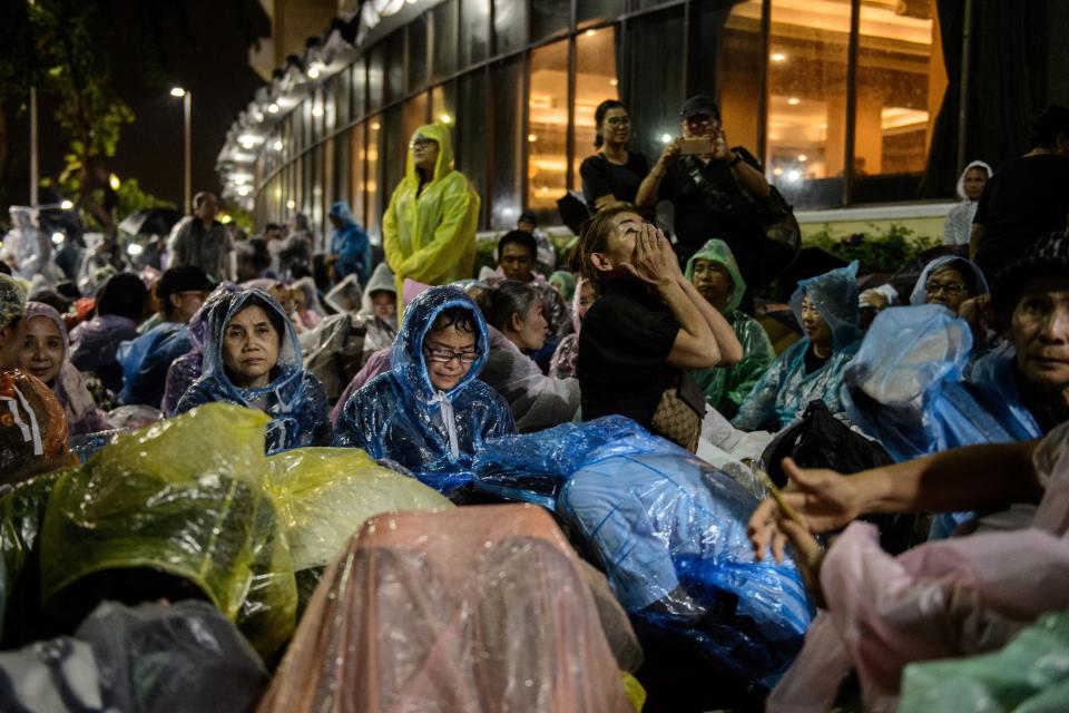 Mourners shelter from the rain while waiting for the funeral of the late Thai King Bhumibol Adulyadej in Bangkok on Oct. 24, 2017.