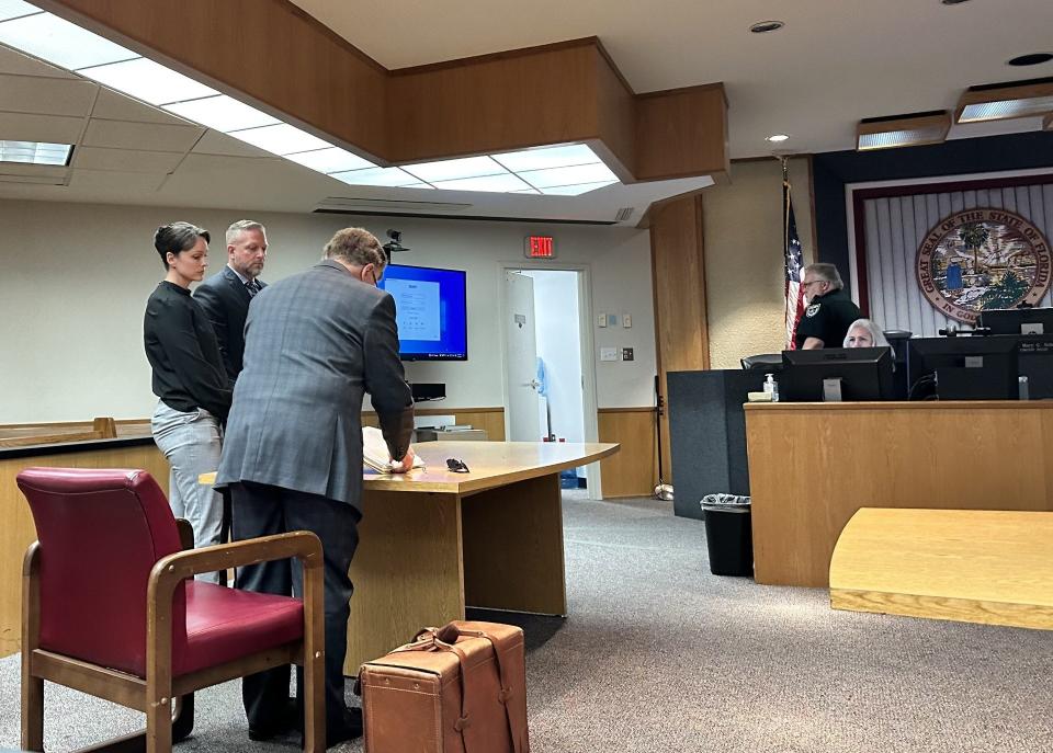 Daytona Beach Shores police officers Jessica Long, left, and Michael Schoenbrod, center, prepare to leave a Volusia County Annex courtroom last month with their attorney, Michael Lambert. A judge at the hearing ruled in favor of opening some records from investigations into their jailing of their son last October for potty-training purposes