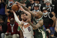 Phoenix Suns' Frank Kaminsky (8) is fouled by Milwaukee Bucks' P.J. Tucker during the second half of Game 3 of basketball's NBA Finals, Sunday, July 11, 2021, in Milwaukee. (AP Photo/Aaron Gash)