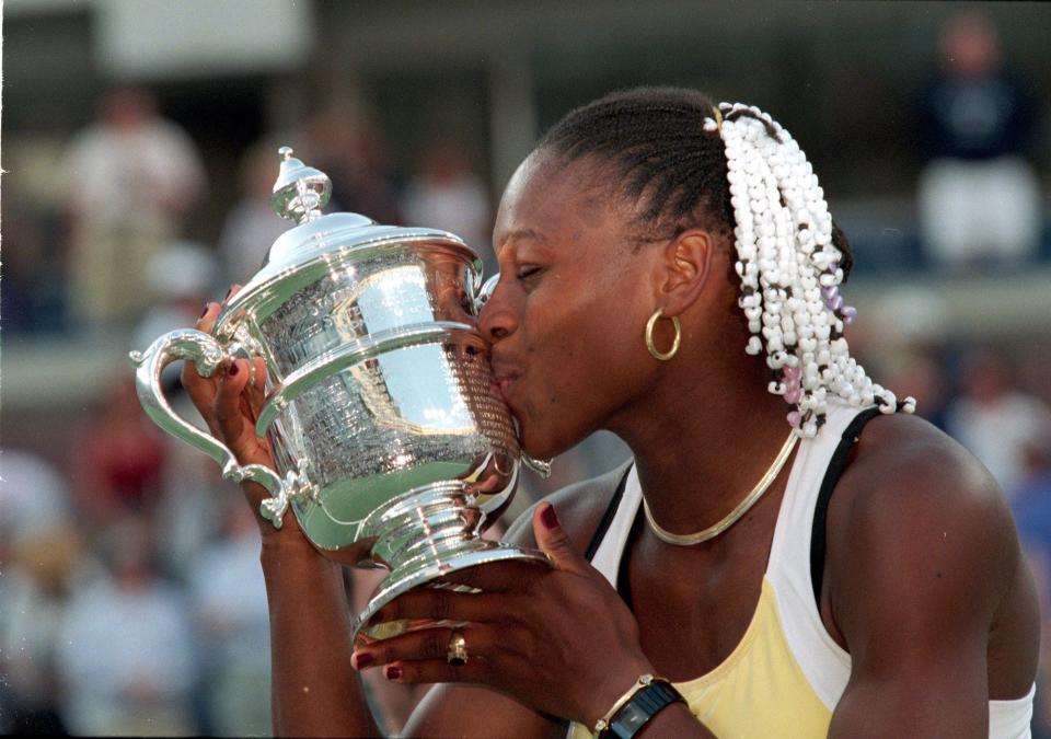 American tennis player Serena Williams kisses her trophy after winning a match (against Martina Hingis of Switzerland) during the US Open at the USTA National Tennis Courts in Flushing Meadows, New York. Williams defeated Hingis 6-3, 7-6, 7-4.