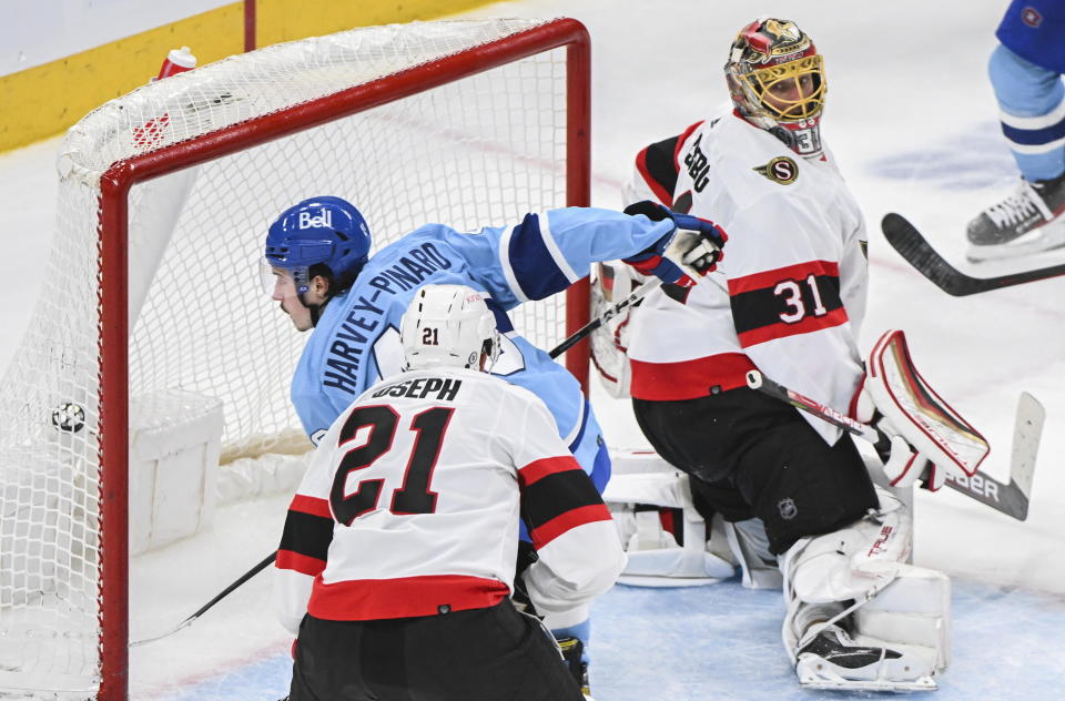 Montreal Canadiens Rafael Harvey-Pinard scores against Ottawa Senators goaltender Anton Forsberg as Senators' Mathieu Joseph defends during the third period of an NHL hockey game, Tuesday, Jan. 31, 2023 in Montreal. (Graham Hughes/The Canadian Press via AP)