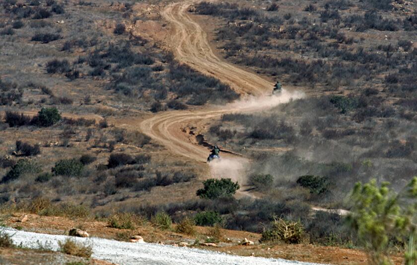 Bartletti, Don –– – September 25, 2007. San Diego, CA. U.S. Border Patrol agents ride ATV's across land owned by National Enterprises Inc. The undeveloped land butts up against the U.S./Mexico border fence east of the Otay Mesa port of entry. The company filed a lawsuit charging the U.S. Border Patrol with building roads and trespassing on the private property without their permission.