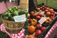 This combination of photos shows green peppers, left and heirloom tomatoes for sale at a farmer's market in Waitsfield, Vt., on Aug. 28, 2021. Signing up for a Community-Supported Agriculture program means getting a box of produce from local farms every week or two. It's a great way to take advantage of summer's bounty, discover new fruits and vegetables, and support the folks who grow food in your area. (AP Photo/Carolyn Lessard)