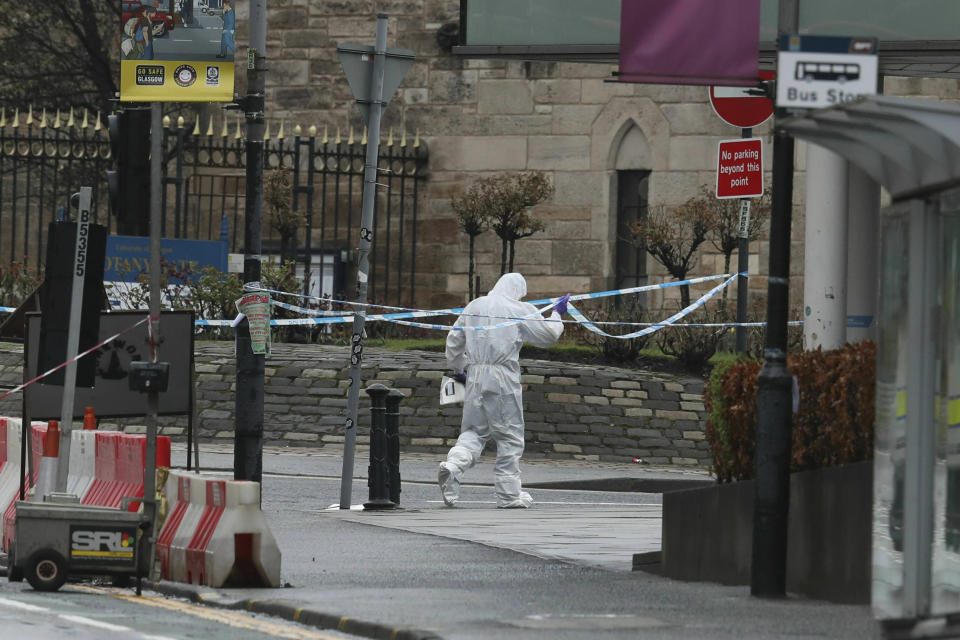 A forensic worker outside the University of Glasgow after the building was evacuated when a suspect package was found in the mailroom, in Glasgow, Scotland, Wednesday March 6, 2019. Buildings at the University of Glasgow were evacuated Wednesday as police examined a suspicious package found in the mailroom, a day after three London transport hubs received letter bombs. (Andrew Milligan/PA via AP)