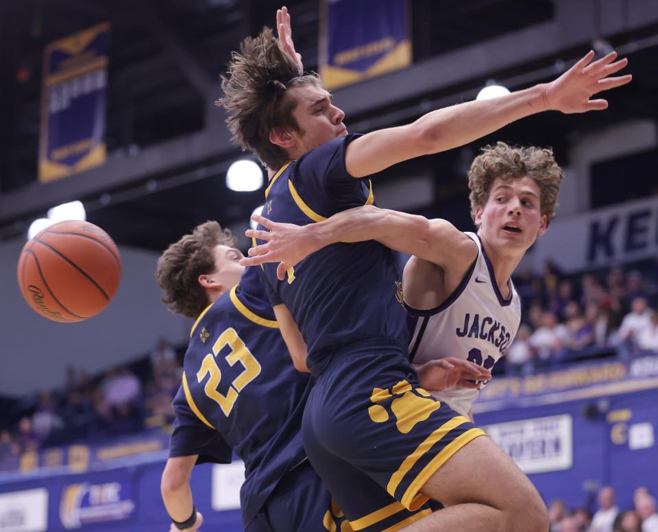 Jackson's Anthony Fuline dishes off the ball under the basket in the second half with defense from St. Ignatius' Jack Zapolnik, 23, and Mike Lamirand during the OHSAA regional semifinal at Kent State, Wednesday, March 13, 2024.