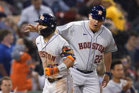 Houston Astros third base coach Omar Lopez (22) celebrates with Jose Altuve, who rounds third after hitting a solo home run during the sixth inning of the team's baseball game against the Boston Red Sox at Fenway Park, Thursday, June 10, 2021, in Boston. (AP Photo/Elise Amendola)