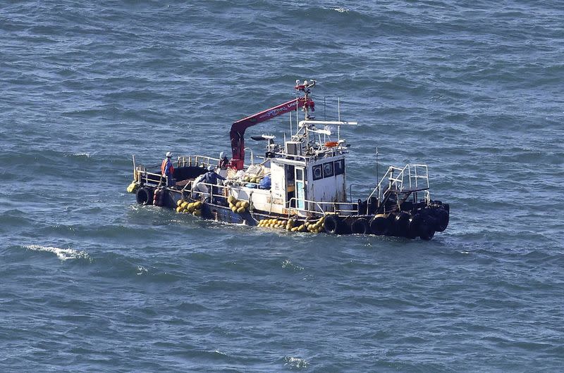 A boat collecting seawater for monitoring radioactive materials in the sea is seen near the Fukushima Daiichi Nuclear Power Plant, in Okuma