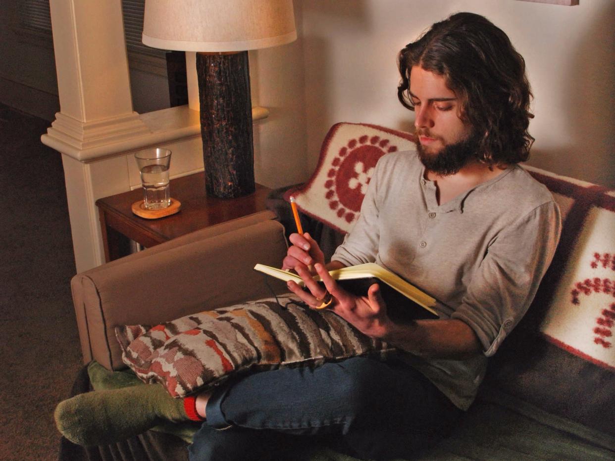 man sitting on a couch writing