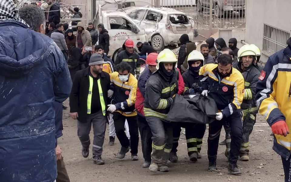 Firefighters carry the body of a victim in Diyarbakir, in southeastern Turkey, Monday, Feb. 6, 2023. (Mahmut Bozarsan/AP)