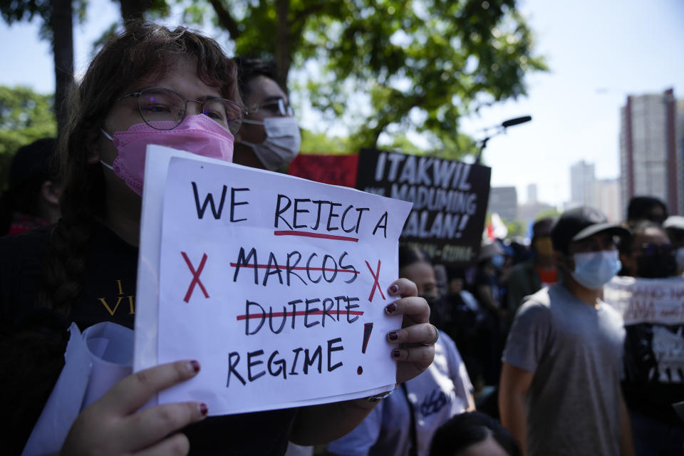 A protester hold slogans during a rally against presidential frontrunner Ferdinand "Bongbong" Marcos and running mate Sara Duterte, daughter of the current president, during a rally in Pasay, Philippines on Friday, May 13, 2022. Allies of the Philippines' presumptive next president, Ferdinand "Bongbong" Marcos Jr., appear set to strongly dominate both chambers of Congress, further alarming activists after the late dictator's son scored an apparent election victory that will restore his family to the seat of power. (AP Photo/Aaron Favila)