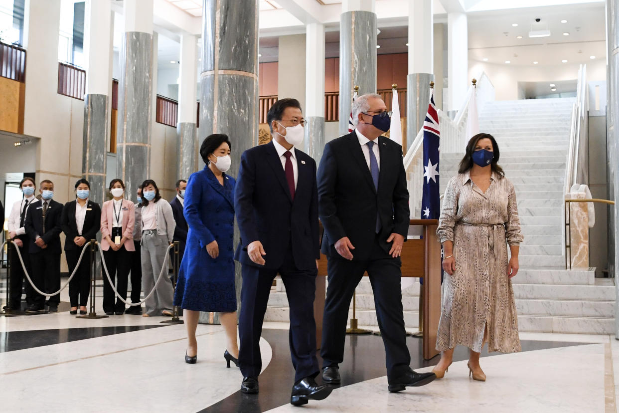 South Korean President Moon Jae-in, second left, and his wife, Kim Jung-sook, left, walk with Australian Prime Minister Scott Morrison and his wife, Jenny, right, at Parliament House, in Canberra, Australia, Monday, Dec. 13, 2021. Moon is on a two-day official visit to Australia. (Lukas Coch/Pool Photo via AP)