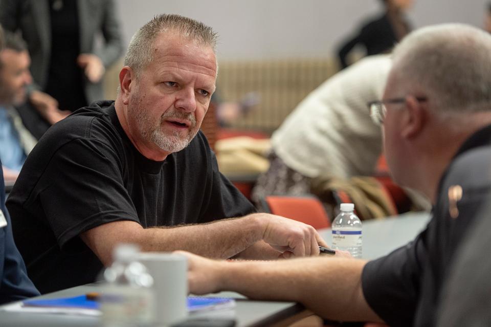 Local United Steel Workers Union President Troy Dills, left, speaks to Canton Police Chief Scott Sluder following the meeting on the Canton paper mill closure March 10, 2023.