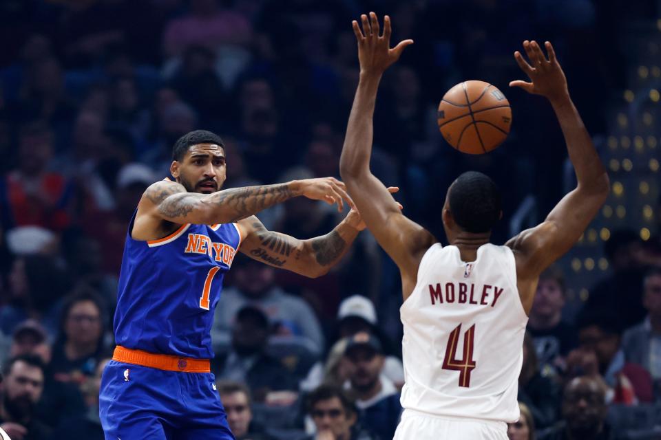 New York Knicks forward Obi Toppin (1) passes the ball as Cleveland Cavaliers forward Evan Mobley (4) defends during the first half of an NBA basketball game Friday, March 31, 2023, in Cleveland. (AP Photo/Ron Schwane)