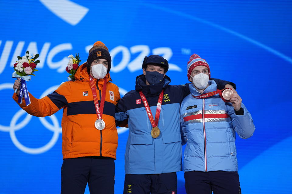 From left, silver medalist Patrick Roest of the Netherlands, gold medalist Nils van der Poel of Sweden and bronze medalist Hallgeir Engebraaten of Norway celebrate on the podium during a medal ceremony for the men's speedskating 5,000-meter race at the 2022 Winter Olympics, Monday, Feb. 7, 2022, in Beijing. ((AP Photo/Jeff Roberson)