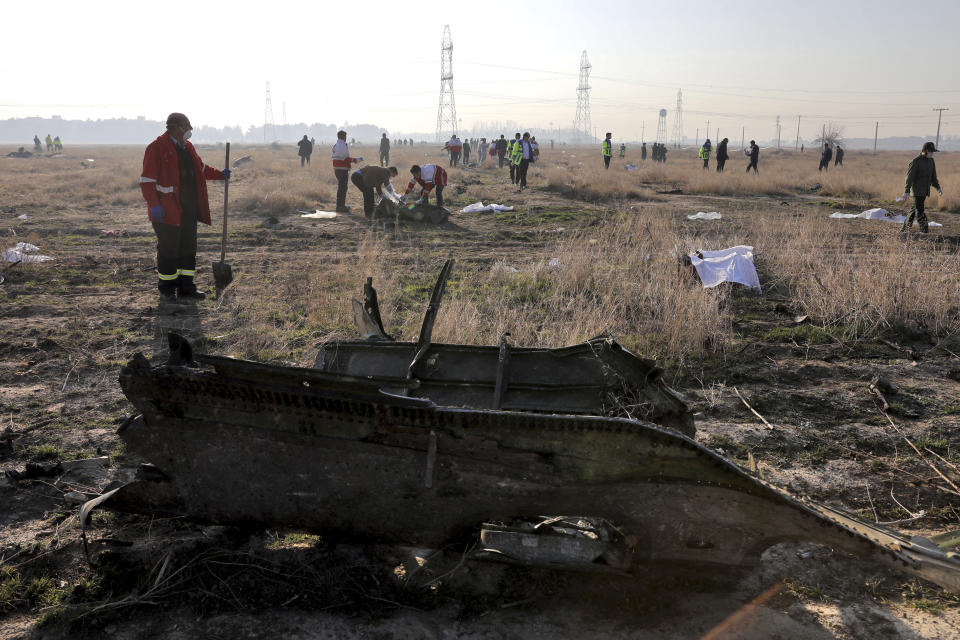 In this Wednesday, Jan. 8, 2020 photo, rescue workers search the scene where a Ukrainian plane crashed in Shahedshahr, southwest of the capital Tehran, Iran. Iran on Friday denied Western allegations that one of its own missiles downed a Ukrainian jetliner that crashed outside Tehran, and called on the U.S. and Canada to share any information they have on the crash, which killed all 176 people on board. (AP Photo/Ebrahim Noroozi)