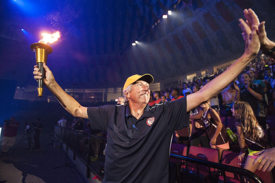 FILE - Olympian Dick Fosbury greets fans while carrying the torch to kick off the Commonwealth Games at the Vines Center on Friday, July 22, 2016, in Lynchburg, Va. Fosbury, the lanky leaper who completely revamped the technical discipline of high jump and won an Olympic gold medal with his “Fosbury Flop,” has died after a recurrence with lymphoma. Fosbury died Sunday, March 12, 2023, according to his publicist, Ray Schulte. He was 76.(Jay Westcott/The News & Advance via AP, File)