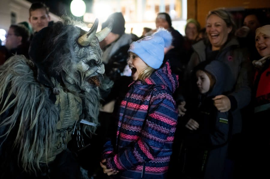 A participant wearing a traditional Krampus costume and a mask performs during a Krampus run in Hollabrunn, Austria, Sunday, Nov. 26, 2022. (AP Photo/Michael Gruber)