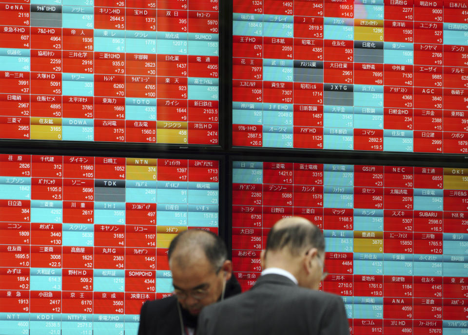 Men walk past an electronic stock board showing Japan's Nikkei 225 index at a securities firm in Tokyo Thursday, Nov. 22, 2018. Asian markets were mostly lower on Thursday as a mixed bag of data from the United States that could point to softening growth rattled investors.(AP Photo/Eugene Hoshiko)