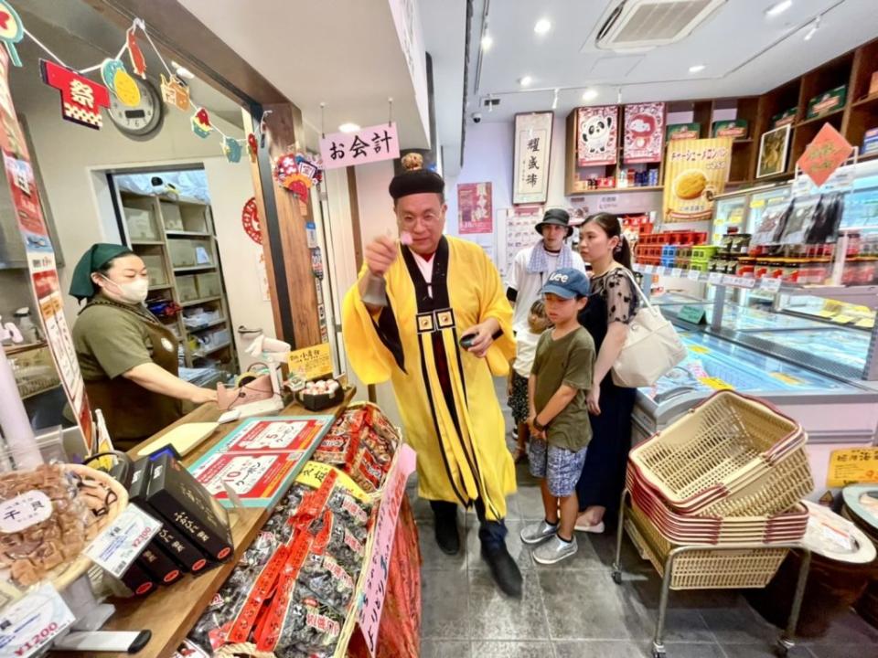 道長陳政宇進入華人商店，灑芙蓉水淨化店面。（記者陳俊文攝）