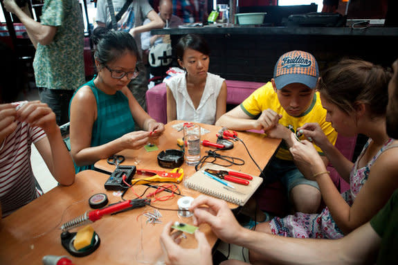 Beijingers learn how to assemble kites that can detect air pollution in a Float Beijing workshop in August 2012.
