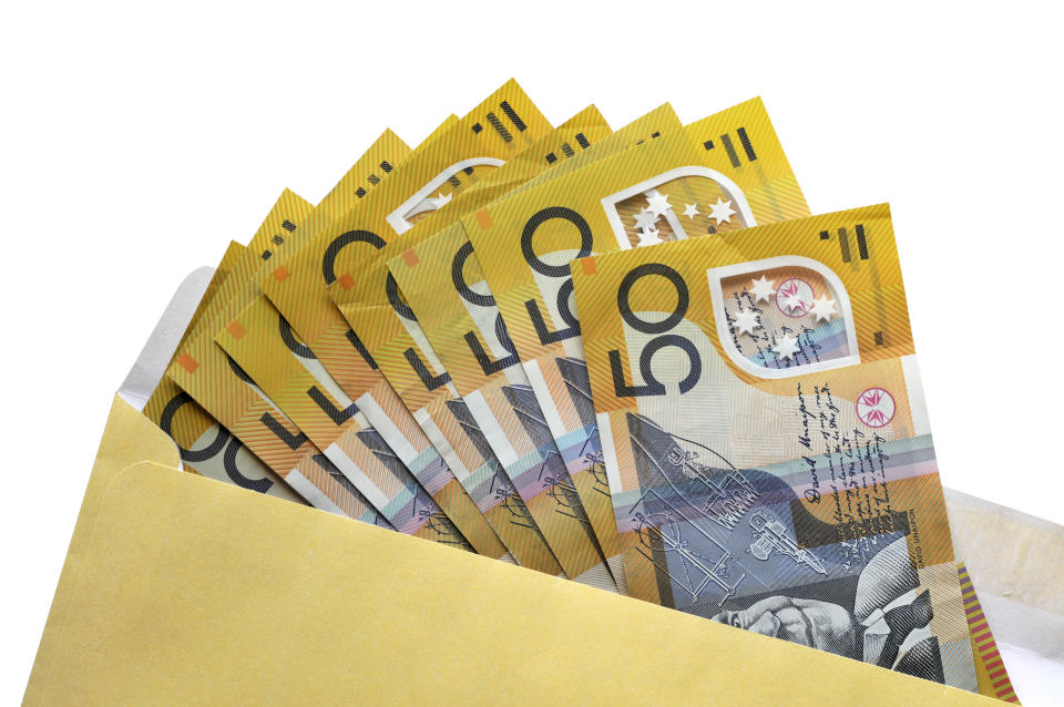 Australian $50 dollar notes coming out of an envelope isolated on white background