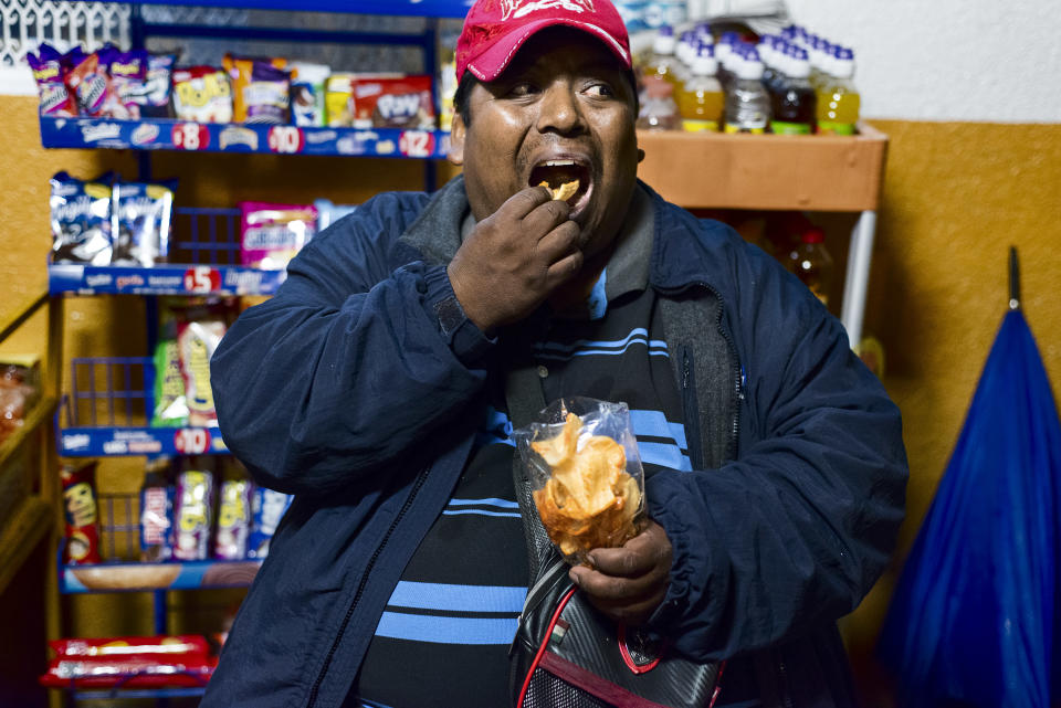 <p>Benito Gutierréz Moreno, 40, does odd jobs in a market, including valet parking, in exchange for some pesos. He often waits all night for a car to park, and while he is waiting he drinks and eats snacks and drinks “refrescos,” or sodas, which he buys in the store. He suffers from severe obesity and is not following diets or treatments to improve his health. In Mexico, 50 percent of the population lives below the poverty line, without access to quality food and with easy access to inexpensive junk food. (Photograph by Silvia Landi) </p>