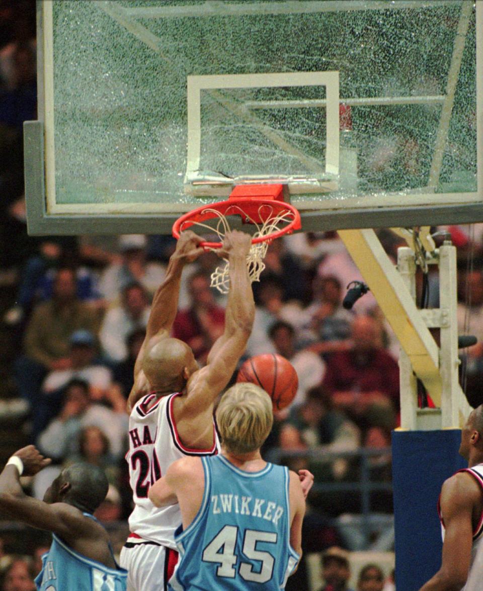 Texas Tech forward Darvin Ham pulls down the backboard and breaks the glass during first half action against North Carolina in the second round of the NCAA basketball tournament Sunday March 17,1996 at the Richmond Coliseum in Richmond, Virginia. North Carolina center Serge Zwikker (45) looks on. AP Photo/Doug Mill)